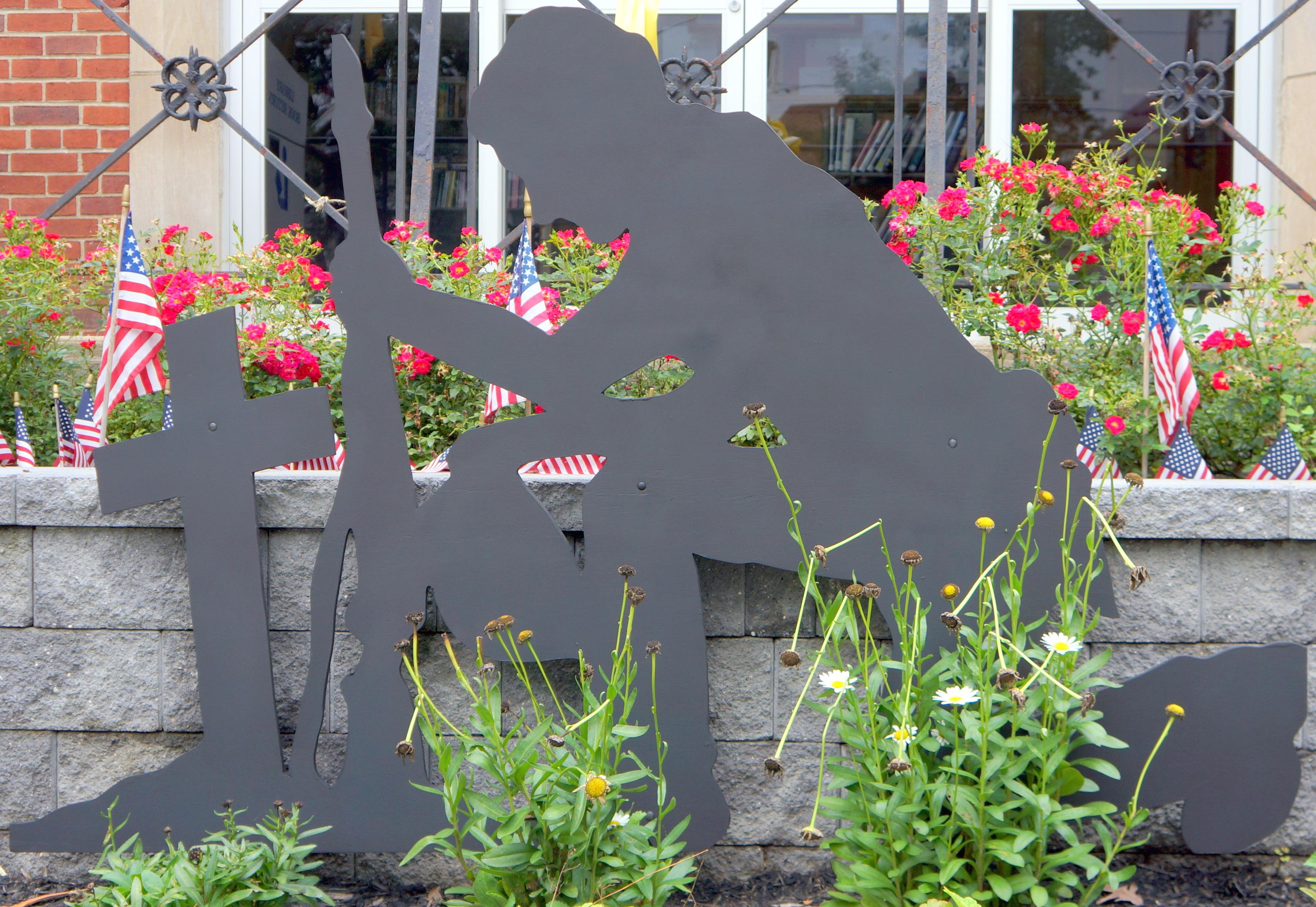 Roselle Park, NJ, veterans memorial features a soldier kneeling in front of a Christian cross.